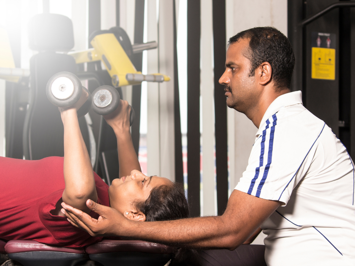 Trainer guiding a client through a fat-loss workout session at Meera's Fitness Centre